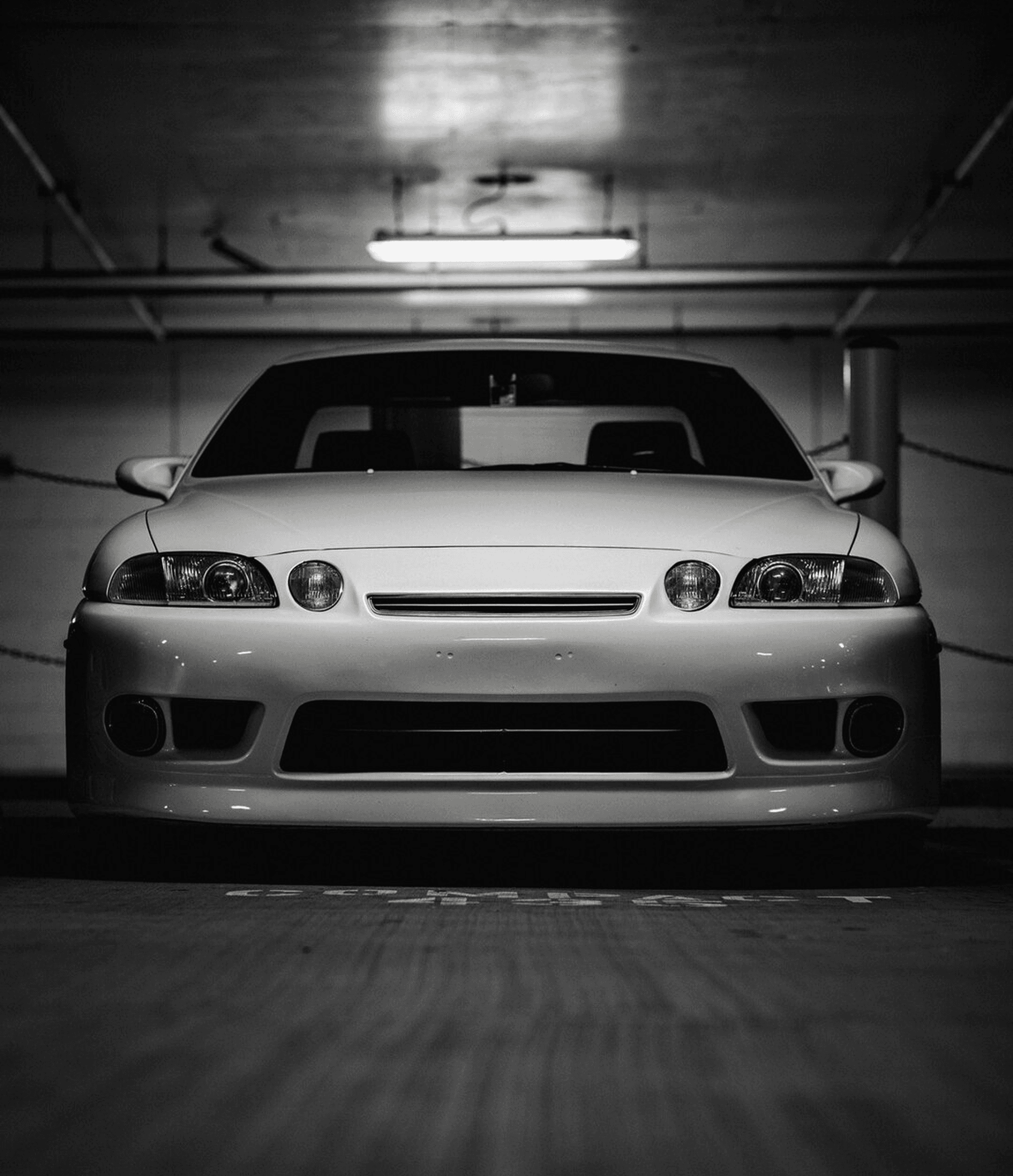 A silver sports car parked in a dimly lit garage